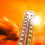 Hot summer or heat wave background, glowing sun on orange sky wi